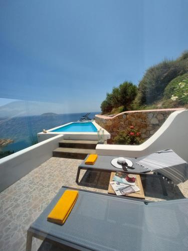 a patio with a table and a swimming pool at Apollon Village Hotel in Anafi