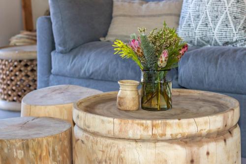 um vaso de flores em cima de duas mesas de madeira em Barefoot Addo Elephant Lodge em Addo