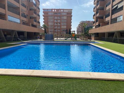 una gran piscina en medio de un edificio en Valencia Ático playa Patacona. Parking incluido en Valencia