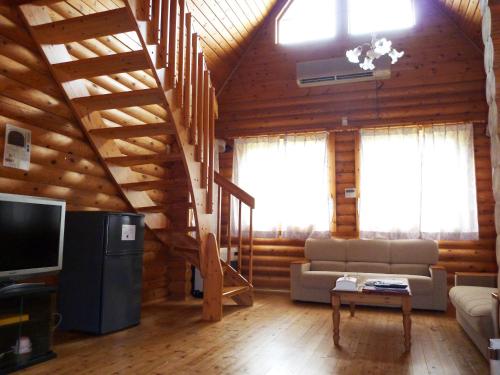 una sala de estar con una escalera en una cabaña de madera en Awone Shirakami Juniko en Fukaura