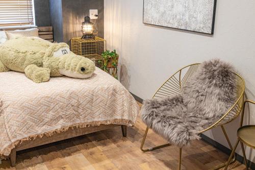 a bedroom with a teddy bear on a bed and a chair at Inn The Omotesando in Tokyo
