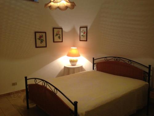 - une chambre avec un lit et une lampe sur une table dans l'établissement Villa San Michele, à San Pietro in Bevagna