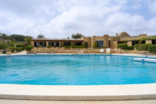 a large swimming pool in front of a building at Hotel Ta' Cenc & Spa in Sannat