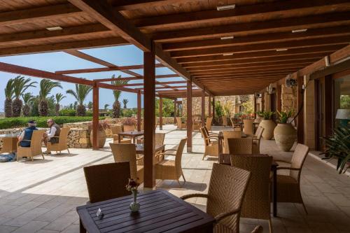 a patio with tables and chairs on a patio at Hotel Ta' Cenc & Spa in Sannat