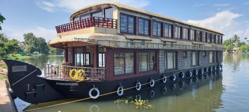 un barco de la casa está sentado en el agua en Meghavarsham Luxury cruise en Alleppey