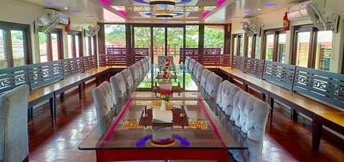 Habitación grande con mesa larga y sillas blancas. en Meghavarsham Luxury cruise en Alleppey