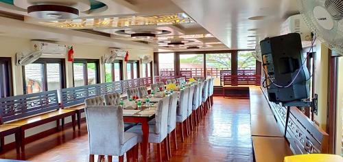 a dining room with a long table and chairs at Meghavarsham Luxury cruise in Alleppey