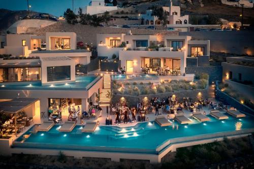 an aerial view of a house with a pool at night at North Santorini - A Luxury Spa Hotel in Pyrgos