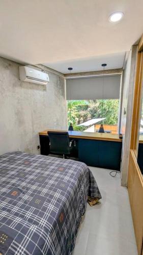 ein Schlafzimmer mit einem Bett und einem großen Fenster in der Unterkunft Beji Loft in Dalung