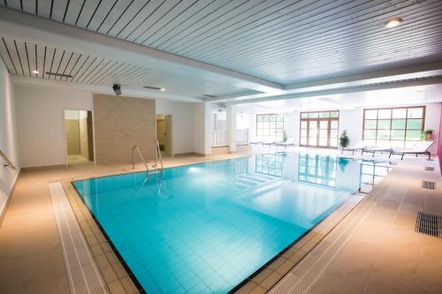 ein großer Pool in einem großen Gebäude in der Unterkunft Das Bergmayr - Chiemgauer Alpenhotel in Inzell