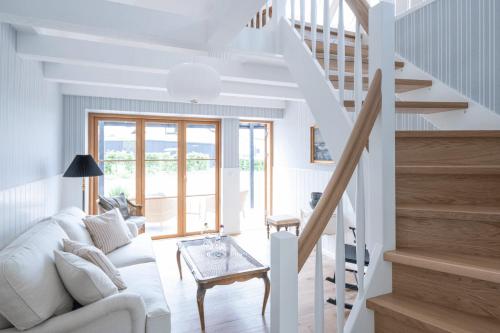 a living room with a white couch and stairs at Stammershalle Badehotel in Bådsted