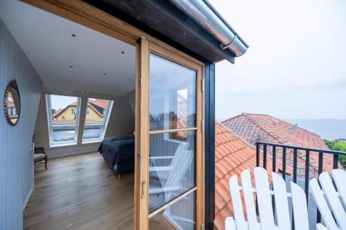 a room with a balcony with a view of the ocean at Stammershalle Badehotel in Bådsted