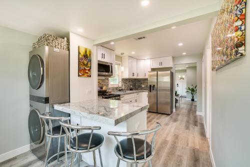 a kitchen with white cabinets and a island with bar stools at Game Nights, BBQs and Family Fun Chicago Area Hub in Des Plaines