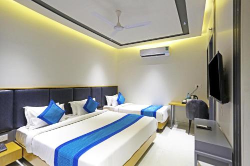 ニューデリーにあるHotel Applewood Residency - Offering Free Airport Dropのベッド2台とテレビがあるホテルの部屋