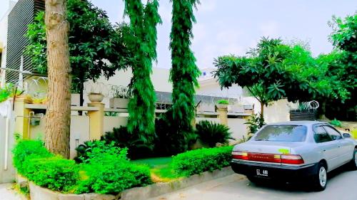 een auto geparkeerd voor een huis met bomen bij Dream Inn Guest House in Islamabad