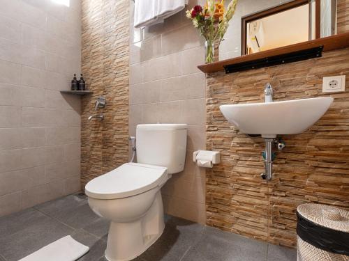 Un baño con un inodoro blanco y un lavabo. en Kubu Belona Canggu, en Canggu