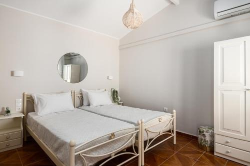 Un dormitorio con una cama con paredes blancas y una ventana en ALS Holiday Houses by Konnect, 900m from Ipsos Beach en Ýpsos