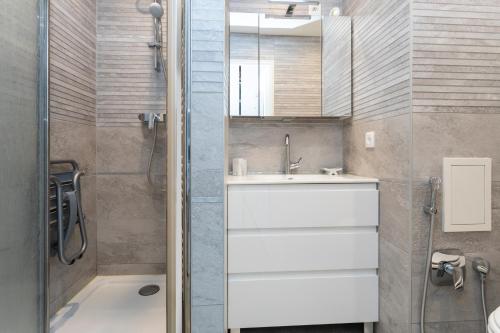 een badkamer met een wastafel en een douche bij LE COSY avec piscine, balcon et parking in Trouville-sur-Mer