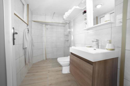 a white bathroom with a sink and a toilet at PerfectSpa Apartment in Humenné