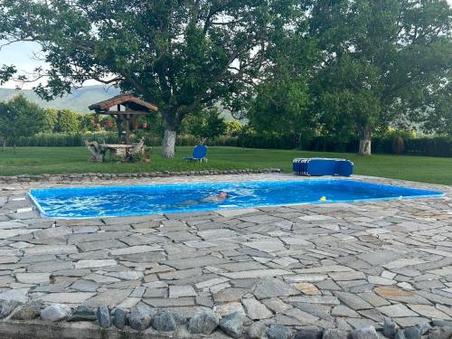 una persona en una piscina en un patio en Къща за гости Мелницата en Elhovo