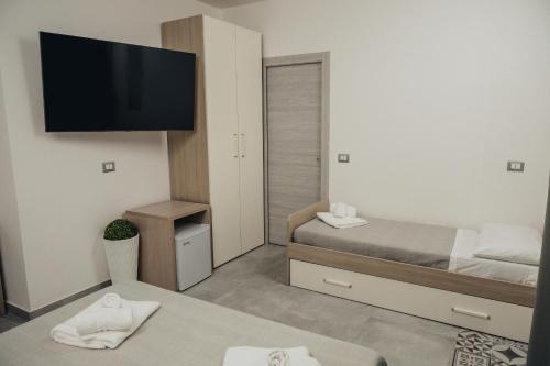 een kleine kamer met 2 bedden en een flatscreen-tv bij B&B OASI SUL MARE San Salvo Marina in San Salvo