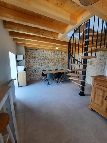 ein Esszimmer mit einem Tisch und einer Steinmauer in der Unterkunft La Char'Vigne in Anglefort