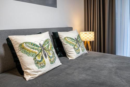 a bed with two butterfly pillows on it at COME2rest - Kalno namai in Juodkrantė