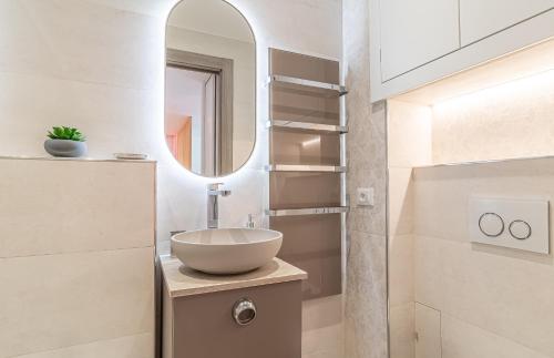 une salle de bain avec un lavabo et un miroir dans l'établissement Le 182 promenade du soleil, à Menton