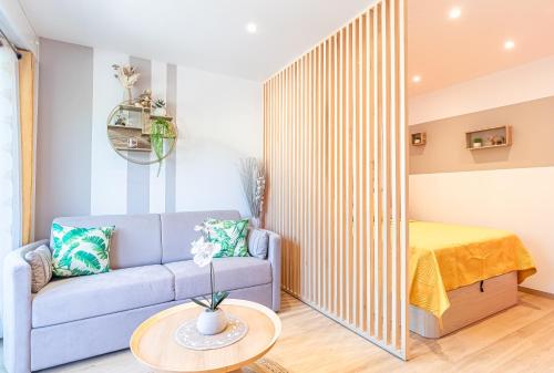 un salon avec un canapé et un lit dans l'établissement Le 182 promenade du soleil, à Menton