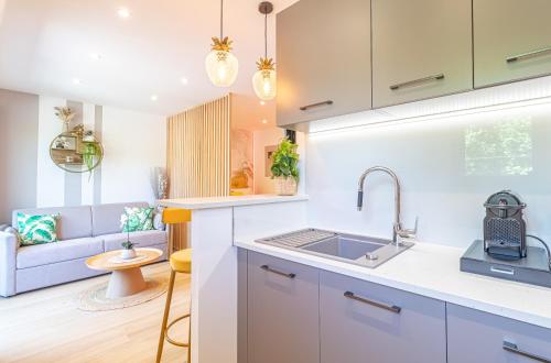 une cuisine avec un évier et un salon dans l'établissement Le 182 promenade du soleil, à Menton