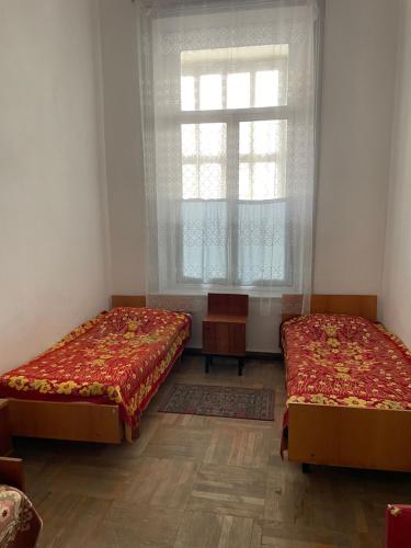 two beds sitting in a room with a window at Firuza Hostel in Borjomi