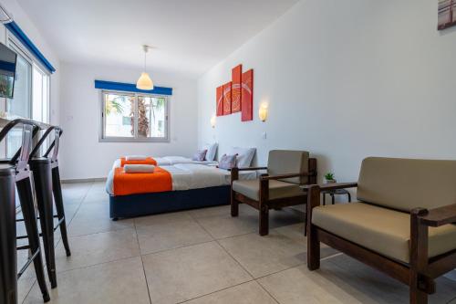 1 dormitorio con 1 cama, mesa y sillas en Tangerine Studio with Pool in Ayia Napa en Ayia Napa