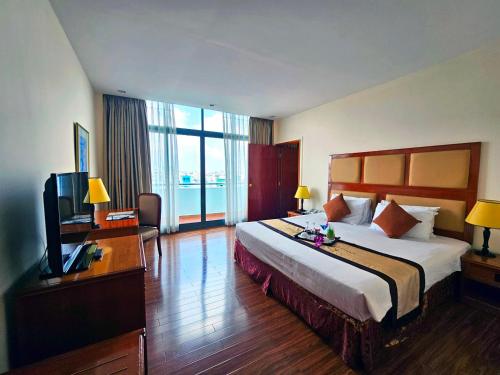 a hotel room with a bed and a television at Ramana Saigon Hotel in Ho Chi Minh City