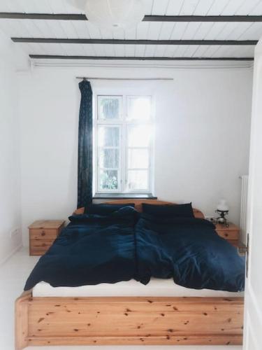 a bedroom with a large bed and a window at Urlaub auf einem alten Resthof am Meer in Gelting