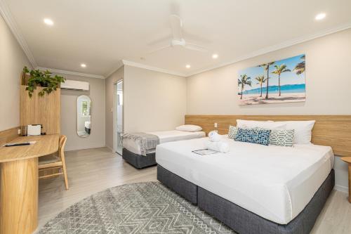 a bedroom with two beds and a desk at Seagulls in Townsville