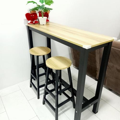a table and two stools in a living room at The 88 Homestay in Batu Pahat