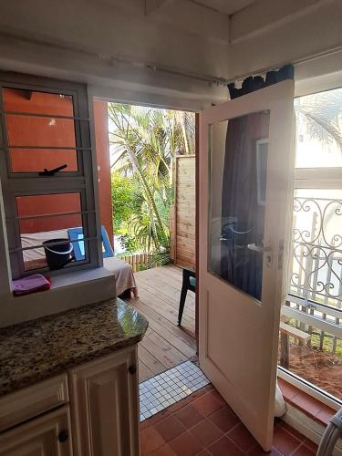 a kitchen with a door open to a patio at Ocean Walk Penguin in Zinkwazi Beach