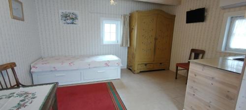 a bedroom with a bed and a cabinet in it at Labanoro troba in Labanoras