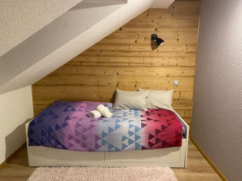 Muhlbach-sur-MunsterにあるAu p’tit nid douillet de Léaの木製の壁のベッドルーム1室(ベッド1台付)
