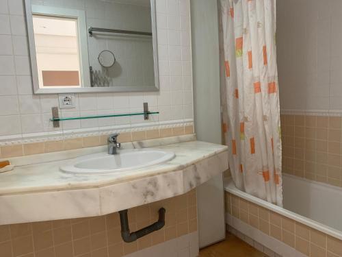 een badkamer met een wastafel, een spiegel en een douche bij Penthouse Isla de Altea in Altea