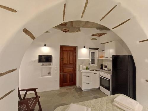uma cozinha com um frigorífico preto e armários brancos em Sea Melody Tinos em Ayios Sostis