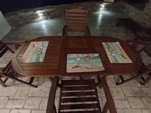 a wooden table with two chairs and a wooden table with at Sea Melody Tinos in Agios Sostis