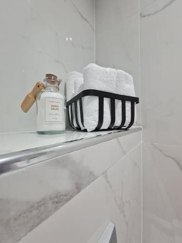 a bathroom shelf with towels and a bottle of soap at Mias luxury apartment in Rijeka