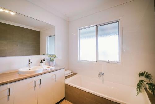 a bathroom with a sink and a tub and a window at The Mains Guest House 2 Bedroom Farm Stay in Corrigin