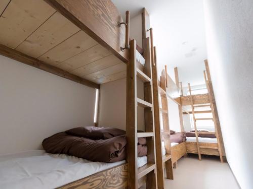 a bedroom with two bunk beds and a ladder at Osaka Namba Hostel MIYABI in Osaka