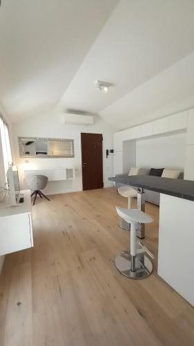 Camera bianca con letto e pavimento in legno. di Una magnolia in Cademartori a Blevio