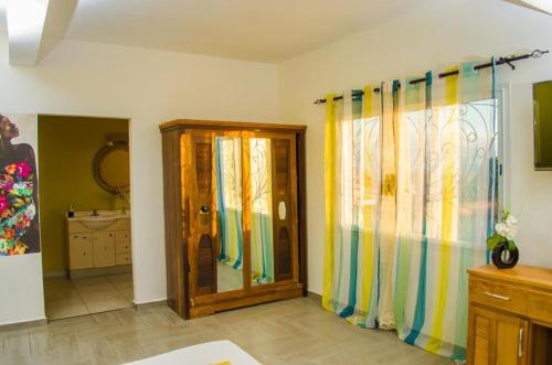 uma casa de banho com uma cortina de chuveiro e um espelho. em Room in Villa - Comfortable and welcoming Suite with terrace overlooking the lake em Antananarivo