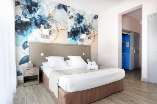 a bedroom with a bed with a blue and white wall at La Petite Sirène in Quiberon