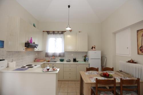 a kitchen with a table and a white refrigerator at SummerAndros Meliti in Andros