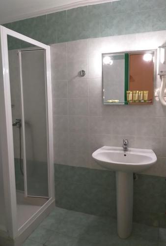 een badkamer met een wastafel en een douche bij Triena Rooms in Mithimna